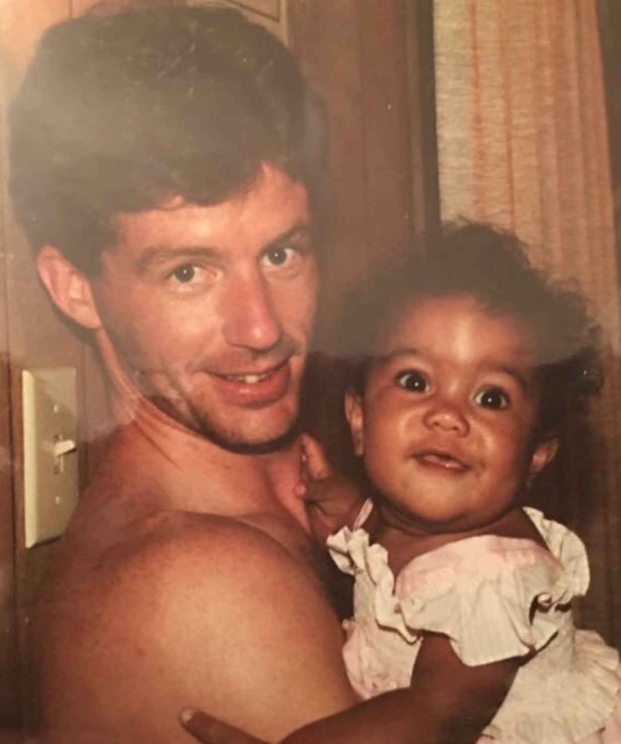 Erica's adoptive father holding her as a baby